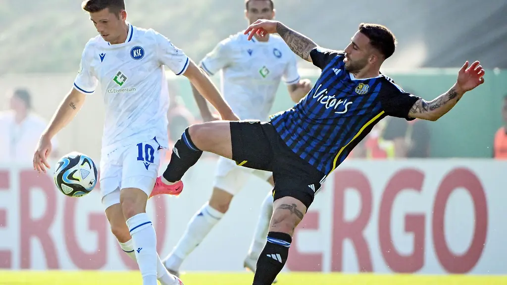 Der-Karlsruher-Marvin-Wanitzek-l-und-der-Saarbruecker-Calogero-Rizzuto-kaempfen-um-den-Ball