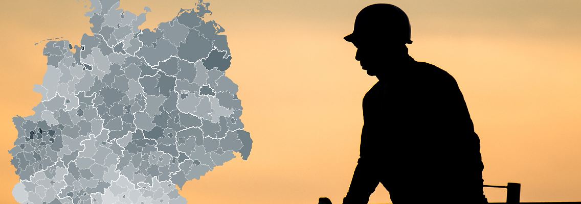 Niedersachsen, Hannover: Die Silhouette eines Bauarbeiters zeichnet sich auf einer Baustelle vor dem verfärbten Morgenhimmel ab.