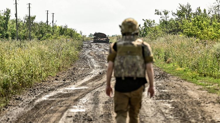 In der Region Saporischschja läuft ein ukrainischer Soldat auf ein zerstörtes russisches Fahrzeug zu.