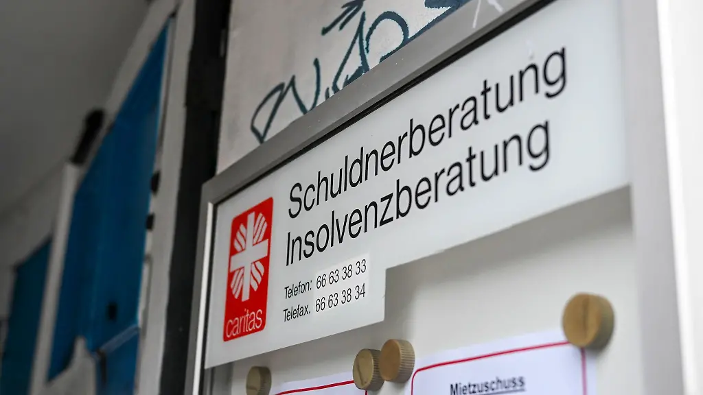 Eine-Schuldnerberatung-und-Insolvenzberatung-der-Caritas-ist-an-einem-Eingang-in-der-Schoenhauser-Allee-in-Pankow-ausgeschildert