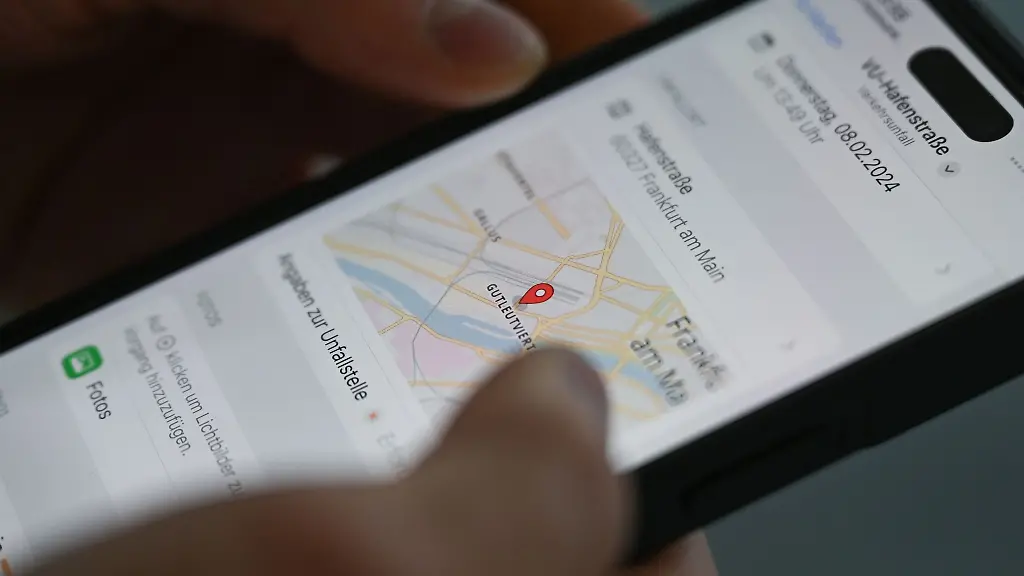 Polizeikommissar-Sam-Elliott-demonstriert-im-Innovation-Hub-110-der-hessischen-Polizei-auf-seinem-Smartphone-den-Einsatz-einer-App