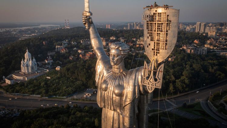 Arbeiter montieren das ukrainische Staatswappen auf das Schild in der Hand des Mutter-Heimat-Denkmals in Kiew, nachdem zuvor die sowjetischen Symbole entfernt worden waren.