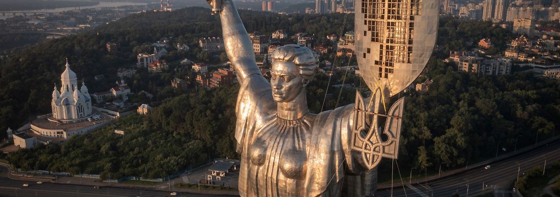 Arbeiter montieren das ukrainische Staatswappen auf das Schild in der Hand des Mutter-Heimat-Denkmals in Kiew, nachdem zuvor die sowjetischen Symbole entfernt worden waren.