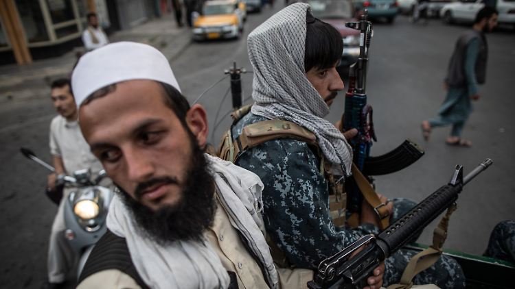 Junge Taliban-Kämpfer patrouillieren auf der Ladefläche eines Pick-Ups in den Straßen von Kabul.