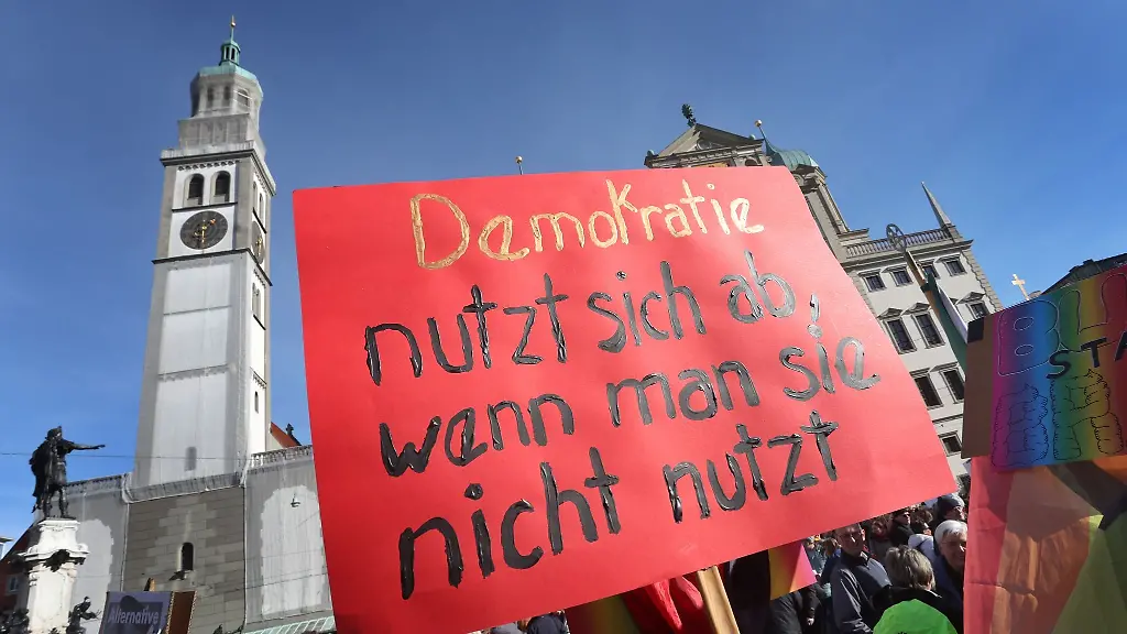 Demonstranten-halten-auf-dem-Rathausplatz-ein-Schild-mit-der-Aufschrift-Demokratie-nutzt-sich-ab-wenn-man-sie-nicht-nutzt