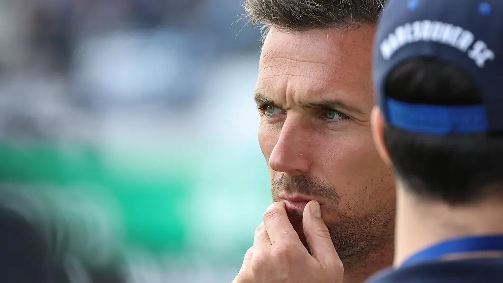 Der-Trainer-Christian-Eichner-vom-Karlsruher-SC-steht-vor-Spielbeginn-auf-dem-Platz