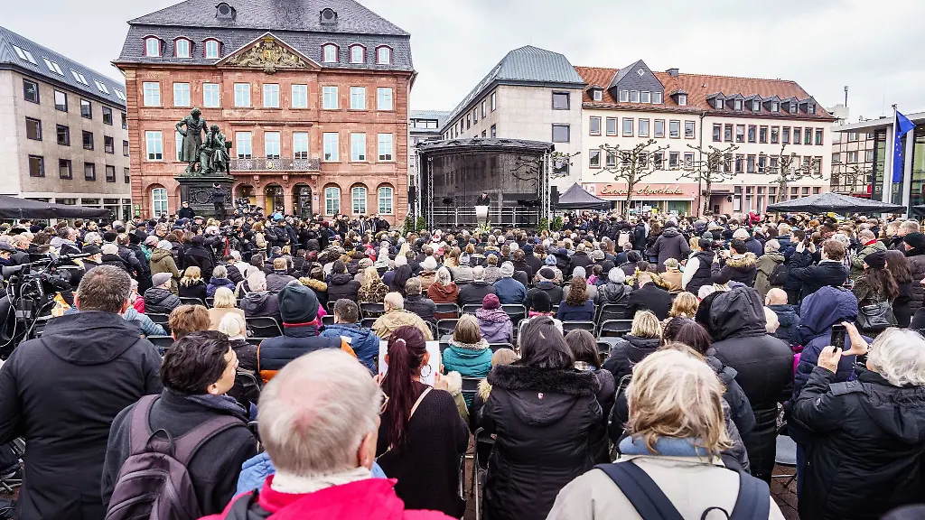 Zahlreiche-Menschen-haben-sich-2023-bei-einer-Gedenkstunde-auf-dem-Marktplatz-eingefunden-bei-der-an-die-neun-Opfer-des-rassistischen-Anschlags-in-Hanau-vor-drei-Jahren-erinnert-wird