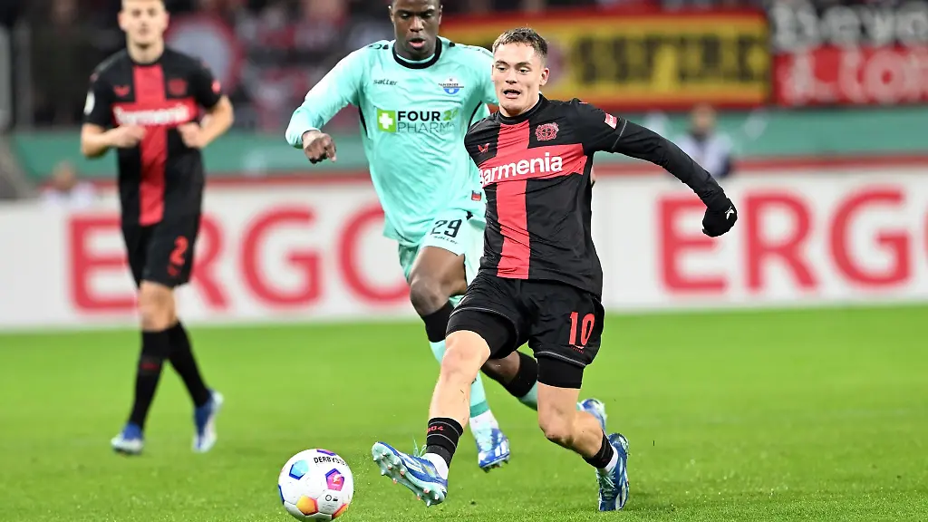 Leverkusens-Florian-Wirtz-r-und-Paderborns-Ilyas-Ansah-kaempfen-um-den-Ball