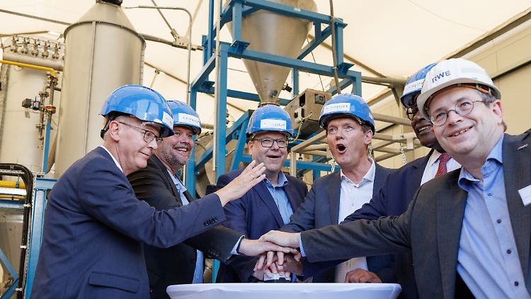Vertreter aus Politik und Wirtschaft drücken den symbolischen Roten Knopf anlässlich der Inbetriebnahme der Pilotanlage. 