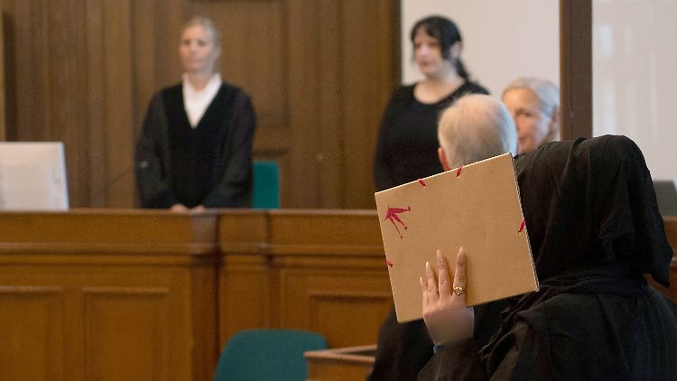 Die Mutter des getöteten Mädchens (r.) betritt als Nebenklägerin den Gerichtssaal im Kriminalgericht Moabit. 