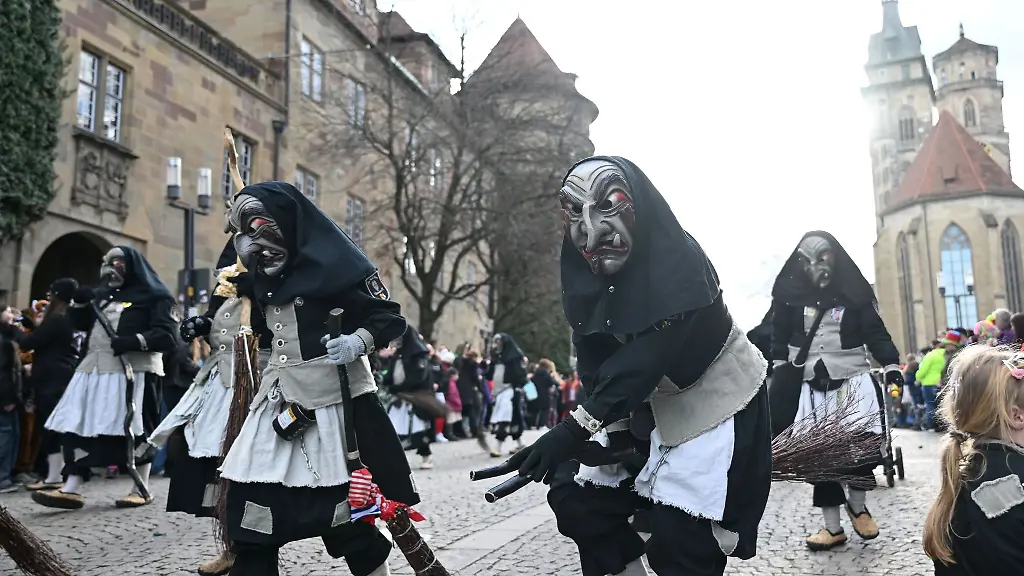 Als-Hexen-verkleidete-Narren-laufen-beim-Fastnachtsumzug-in-der-Stuttgarter-Innenstadt-ueber-den-Schillerplatz