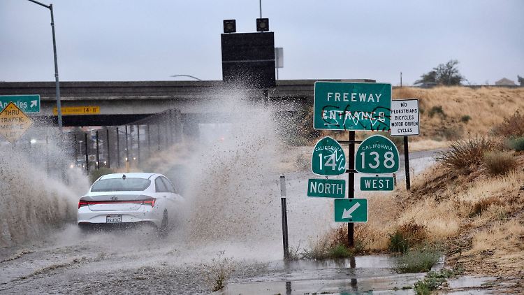 Ein Fahrzeug fährt durch eine überflutete Autobahnauffahrt nahe der kalifornischen Stadt Palmdale.