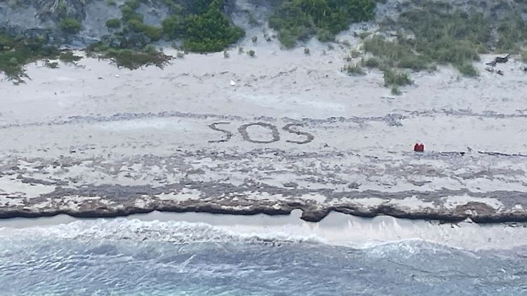 Die US-Küstenwache hat ein Foto mit einem "SOS"-Schriftzug veröffentlicht, der von dem Mann in den Sand gezeichnet wurde. 