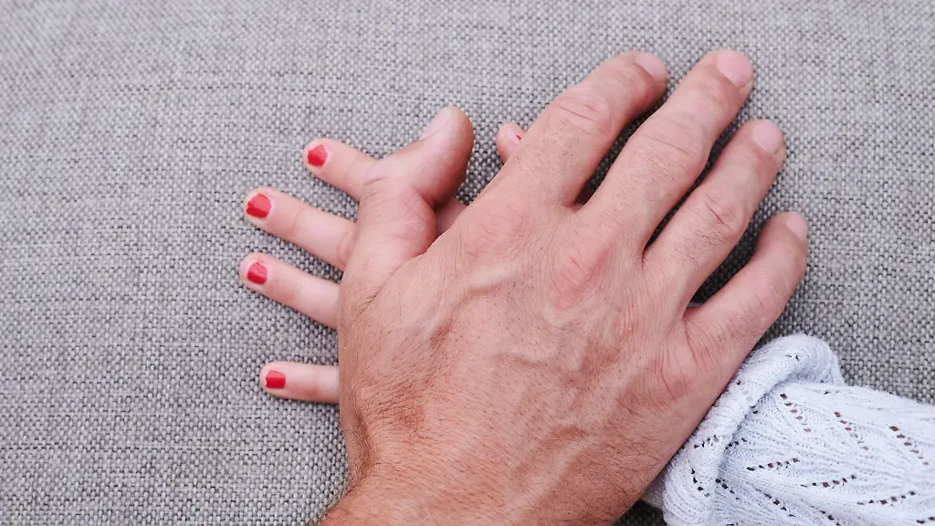 Eine-Maennerhand-liegt-auf-einer-Maedchenhand-gestellte-Szene