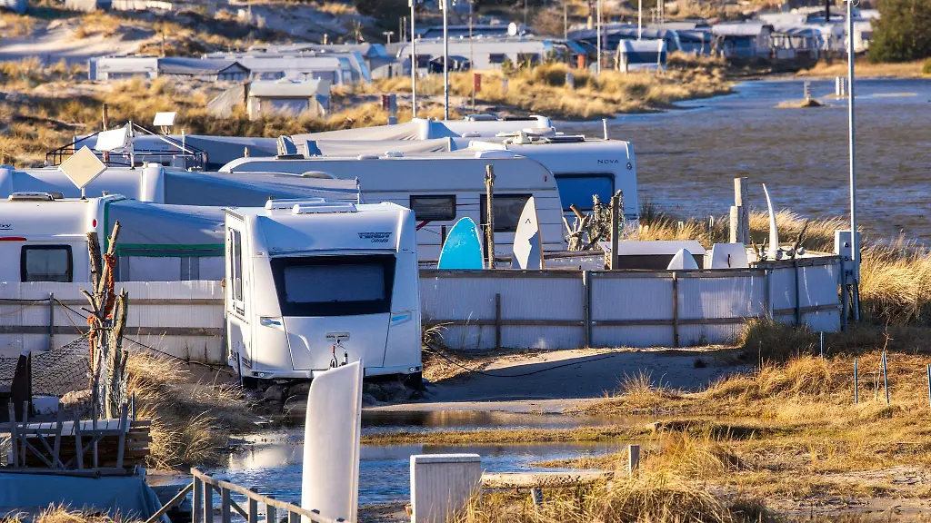 Wohnwagen-stehen-auf-dem-teilweise-unter-Wasser-stehenden-Campingplatz-in-den-Duenen-auf-Fischland-Darss-Zingst