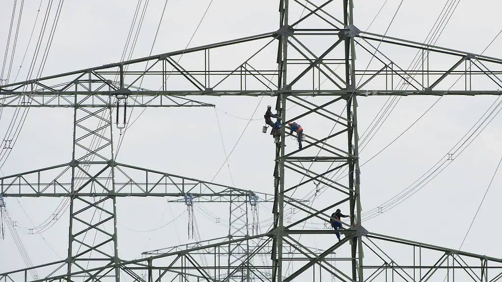 Arbeiter-stehen-am-bei-Wartungsarbeiten-auf-einem-Freileitungsmast-der-Suedwestkuppelleitung