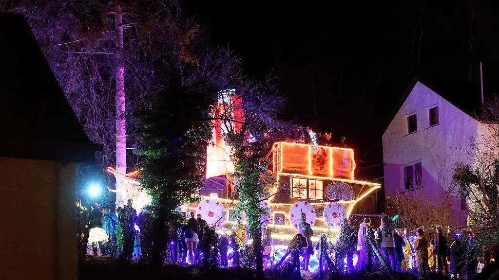 Ein-Karnevalswagen-in-Form-eines-Piratenschiffes-faehrt-beim-Karnevalslichterzoch-durch-den-Eifelort-Eiserfey