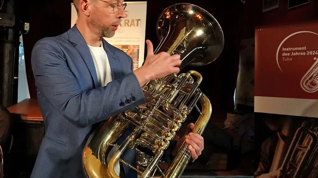 Philipp-Westermann-von-der-Band-Meute-zeigt-waehrend-einer-Pressekonferenz-eine-Tuba