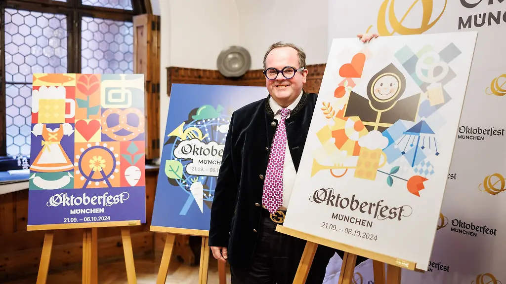 Clemens-Baumgaertner-CSU-Wiesn-Chef-steht-bei-der-Vorstellung-vom-Oktoberfest-Motiv-2024-neben-dem-Siegermotiv-r-von-Annika-Mittelmeier