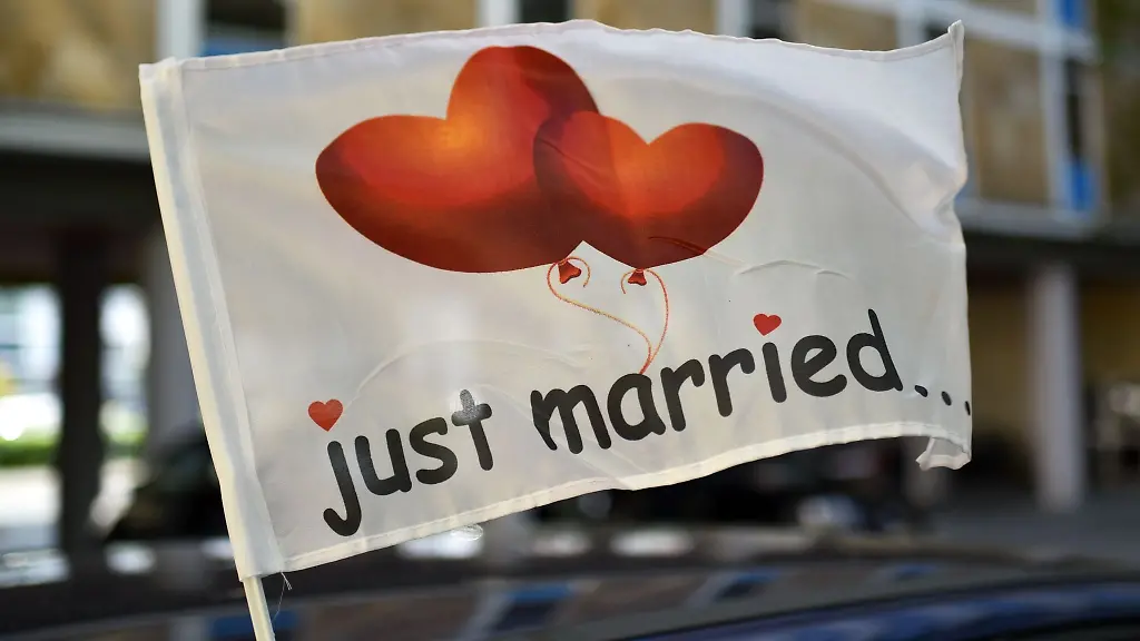 Just-married-frisch-verheiratet-steht-auf-einer-wehenden-Fahne-die-an-einem-Autofenster-festgemacht-ist