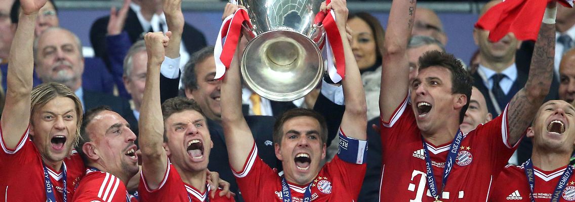 Fußball-Bundesligisten FC Bayern München feiern mit dem Pokal im Jahr 2013.