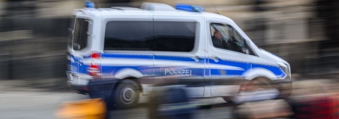 Ein Einsatzwagen der Polizei fährt durch eine Stadt.