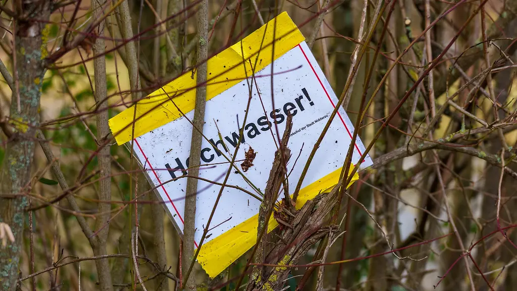 Ein-Schild-auf-dem-Hochwasser-steht-haengt-in-einer-Hecke-fest