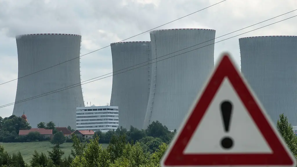 Ein-Hinweisschild-steht-vor-den-Kuehltuermen-des-Atomkraftwerkes-Temelin
