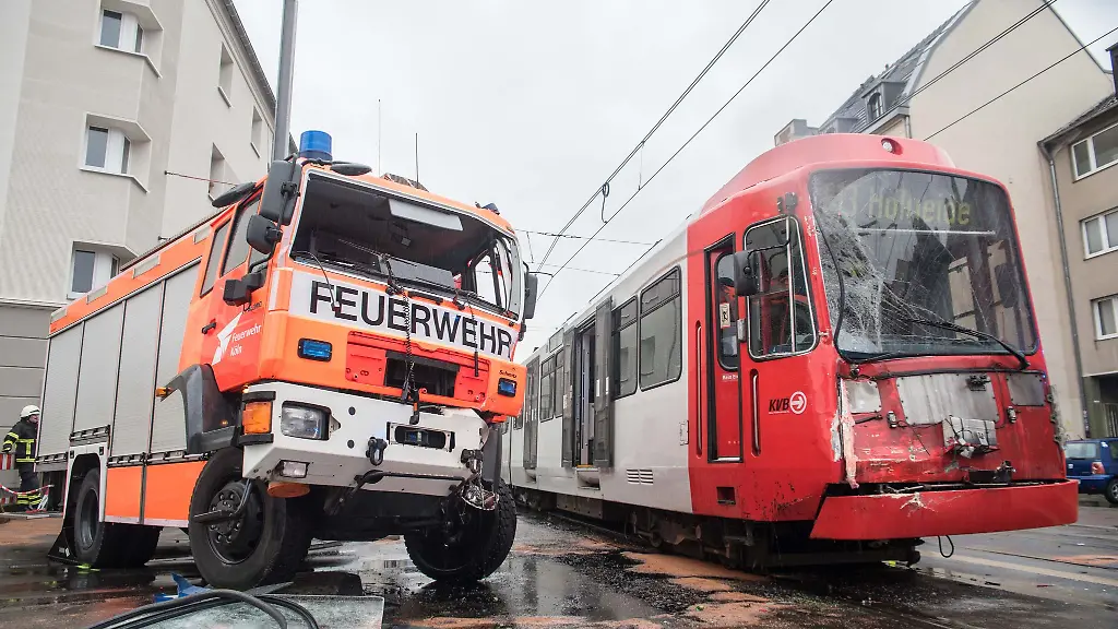 Ein-Feuerwehrauto-und-eine-Stadtbahn-stehen-in-Koeln-beschaedigt-auf-der-Strasse