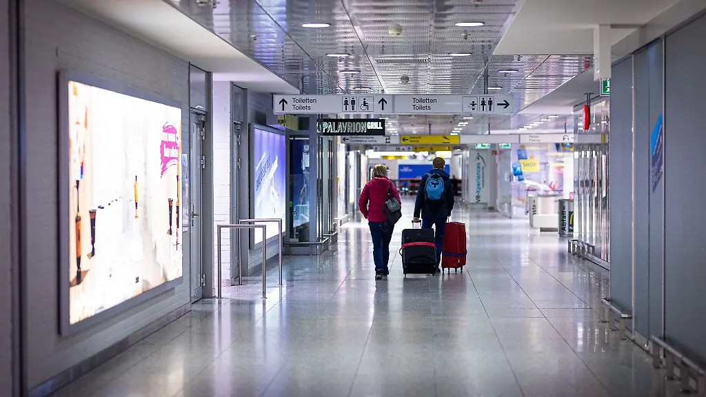 Reisende-gehen-am-Morgen-mit-Koffern-durch-den-Flughafen-Hannover-Langenhagen