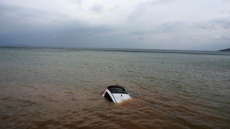 Wie hier in Milina rissen die Fluten alles mit sich. Dieses Auto versinkt im Meer.