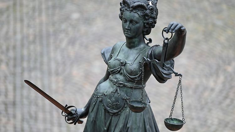 Eine Bronzefigur der Justitia mit Schwert und Waage.