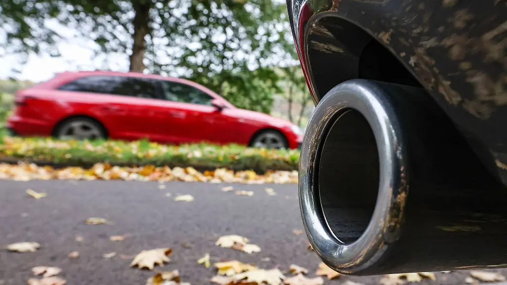 Hinter-dem-Auspuff-eines-Pkw-faehrt-ein-Auto-vorbei