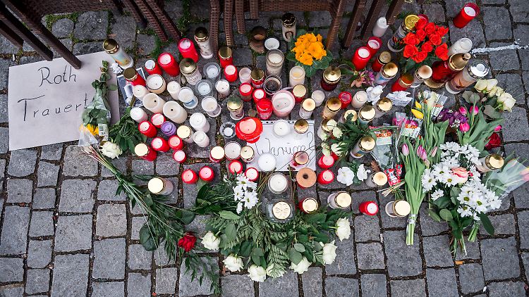 Auf dem Platz vor dem Blumengeschäft, in dem die Getötete aufgefunden wurde, sind Blumen und Kerzen niedergelegt. 