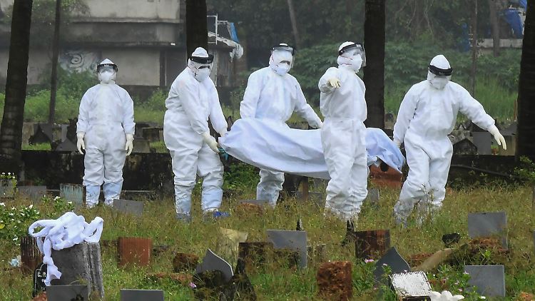 Nach einem Nipah-Virus Ausbruch 2021 im indischen Kerala  tragen Menschen in Schutzanzügen ein 12-jähriges Todesopfer zu Grabe.