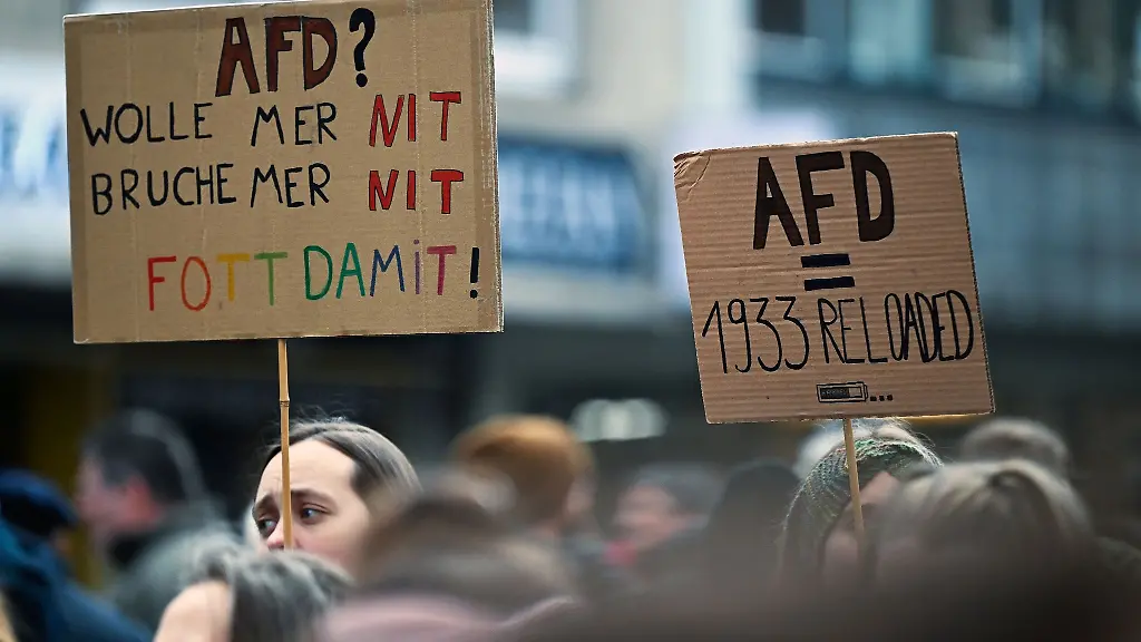 Zahlreiche-Menschen-ziehen-mit-Schildern-bei-einer-Demonstration-durch-die-Innenstadt