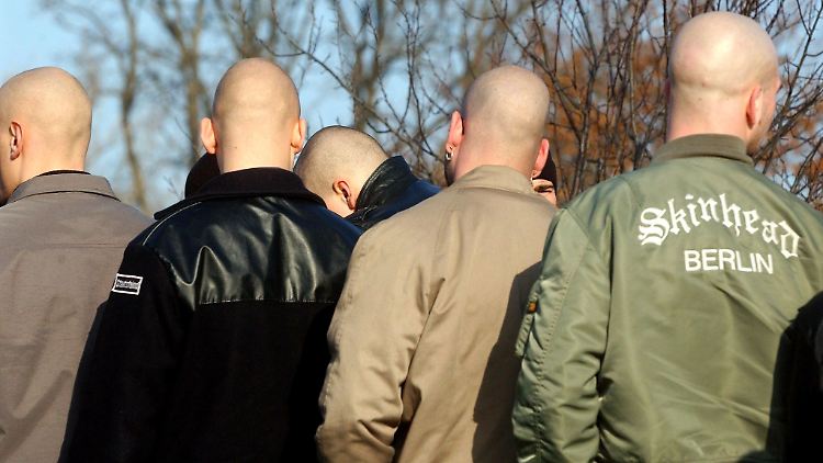 Junge Neonazis stehen während einer Demonstration zusammen.