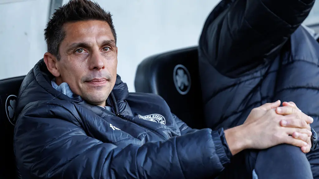Der-Trainer-Marcel-Rapp-von-Holstein-Kiel-sitzt-vor-Spielbeginn-am-Platz