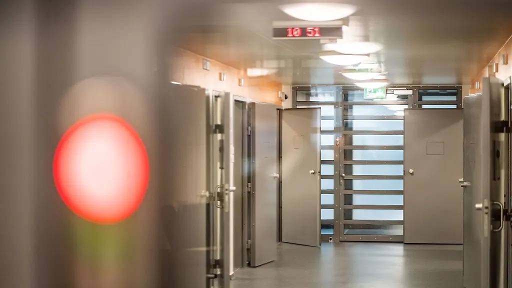 Geoeffnet-sind-die-Zellentueren-beim-Blick-durch-eine-Scheibe-in-den-Flur-der-Abschiebungshaftanstalt-des-Landes-Hessen