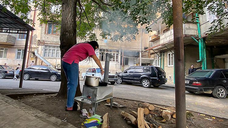 Eine Frau kocht unter freiem Himmel in Stepanakert.