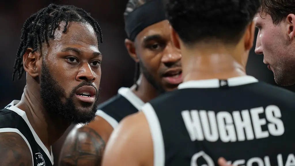 Aljami-Durham-l-r-Vincent-King-Mark-Hughes-und-Lukas-Meisner-sprechen-auf-dem-Spielfeld