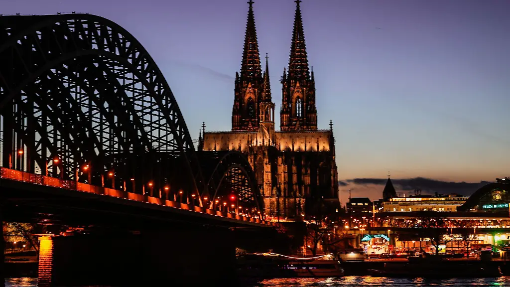 Der-Dom-und-die-Hohenzollernbruecke-sind-am-Abend-beleuchtet