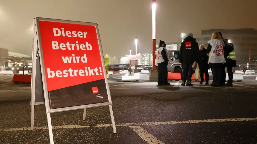 Streikende-stehen-bei-einem-Warnstreik-am-Flughafen-Hamburg-zusammen