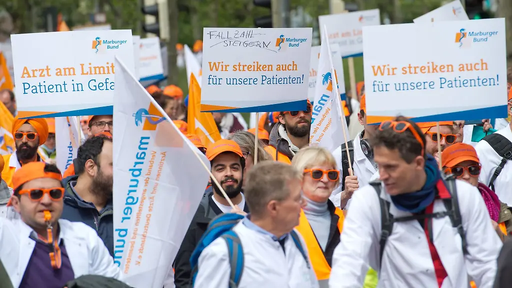 Demonstranten-ziehen-mit-Schildern-bei-einem-Demonstrationsmarsch-durch-die-Stuttgarter-Innenstadt