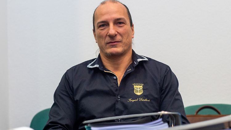 Peter Fitzek sitzt in einem Saal des Landgerichtes hinter Aktenordnern. 