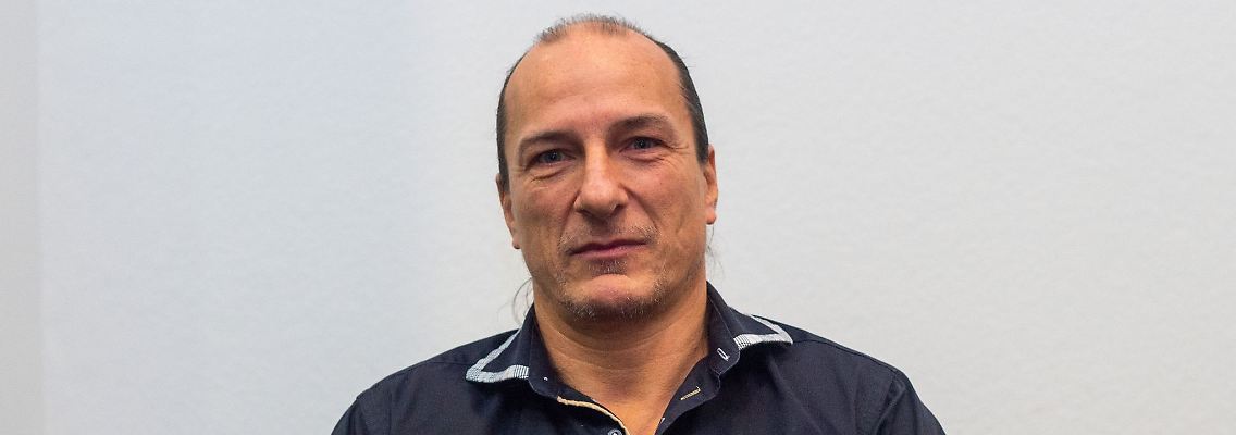 Peter Fitzek sitzt in einem Saal des Landgerichtes hinter Aktenordnern.