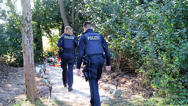 Zwei Polizisten gehen zu der Stelle in unmittelbarer Nähe des Sees in Pragsdorf, wo der Sechsjährige am 14. September mit schwersten Stichverletzungen gefunden wurde.
