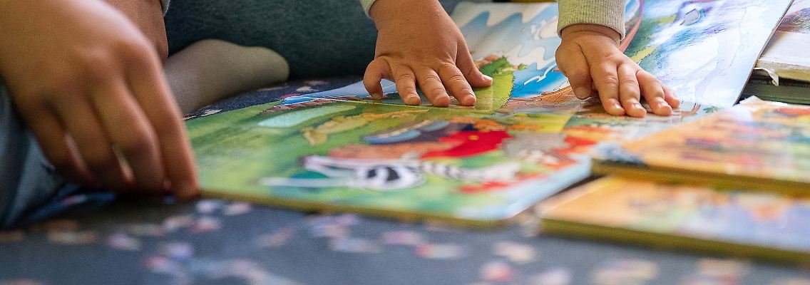 Eine Praktikantin liest in einer Kita Kindern vor.