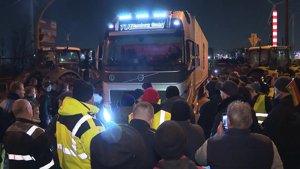 Ein-LKW-steckt-in-der-Blockade-von-Landwirten-auf-einer-Kreuzung-mit-Zufahrt-zum-Hafen-im-Sueden-von-Hamburg