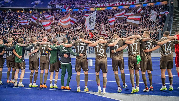 Ein Team vor begeisterten Fans.